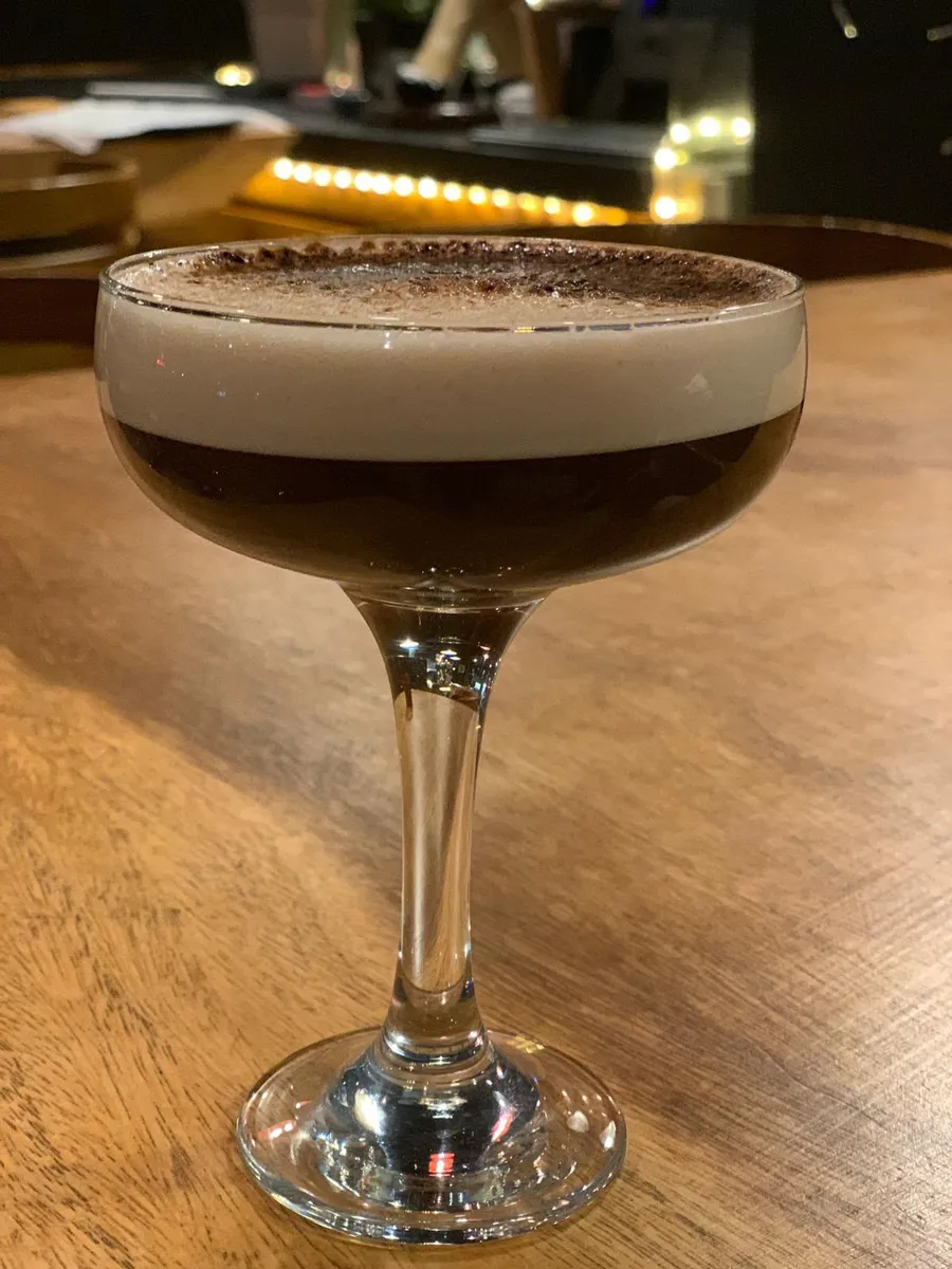 Golden lager beer poured into a glass in a warm bar atmosphere